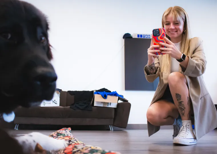 Femme a genou qui photographie un chien avec son mobile / Woman on her knees photographing a dog with her cell phone