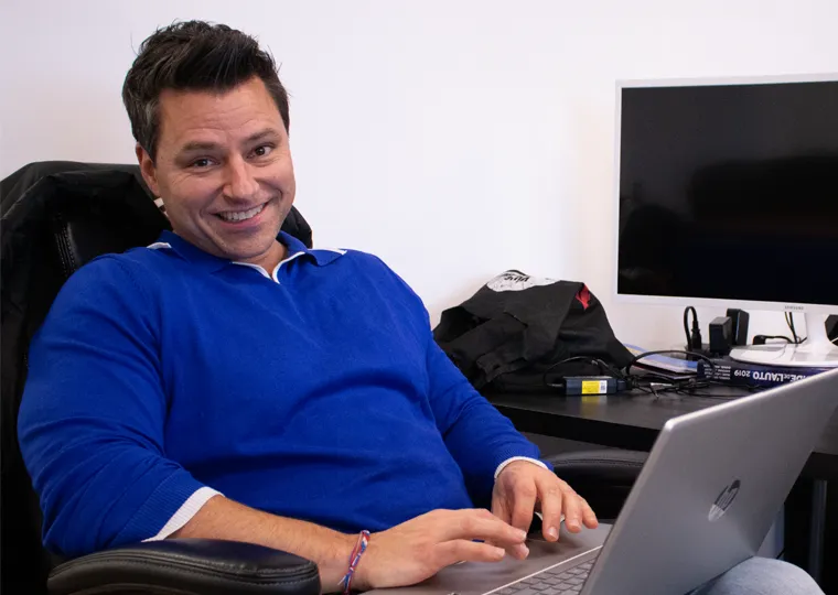 Homme sourire avec portable sur les genoux / Smiling man with laptop on his lap