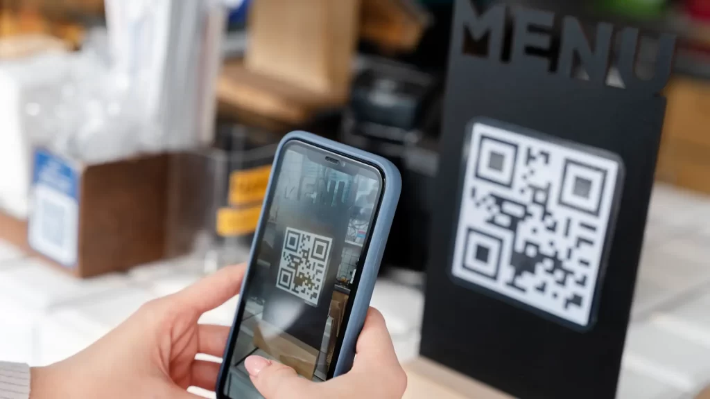 Une femme qui fait l'expérience du phygital à Terrebonne, elle numérise un code QR.